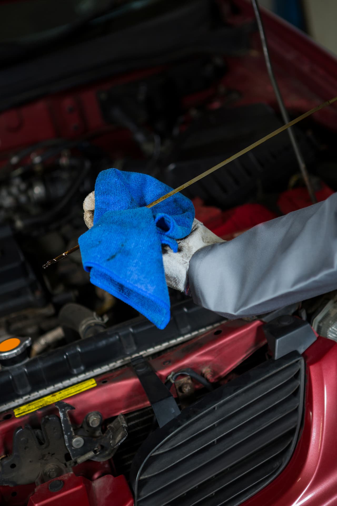 Mecanicien qui verifie le niveau d huile d'une voiture